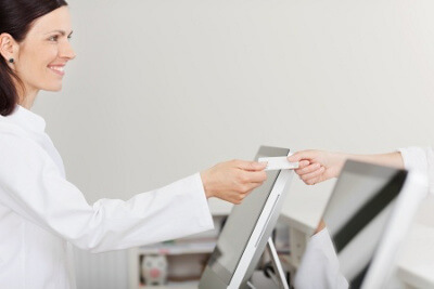 Receptionist Accepting Payment From a Patient