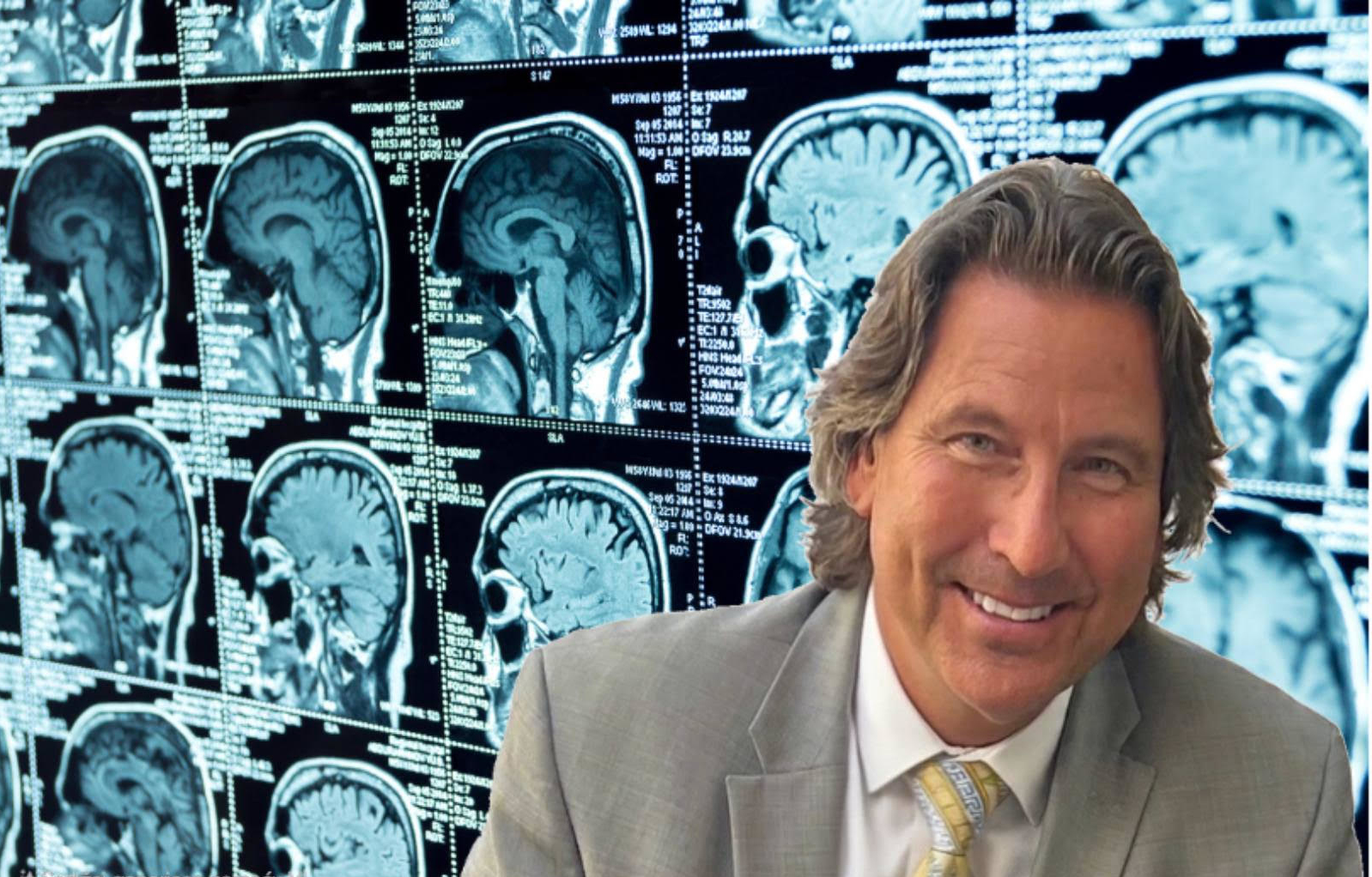 Dr. Perry Mansfield standing in front of an wall of skull x-rays