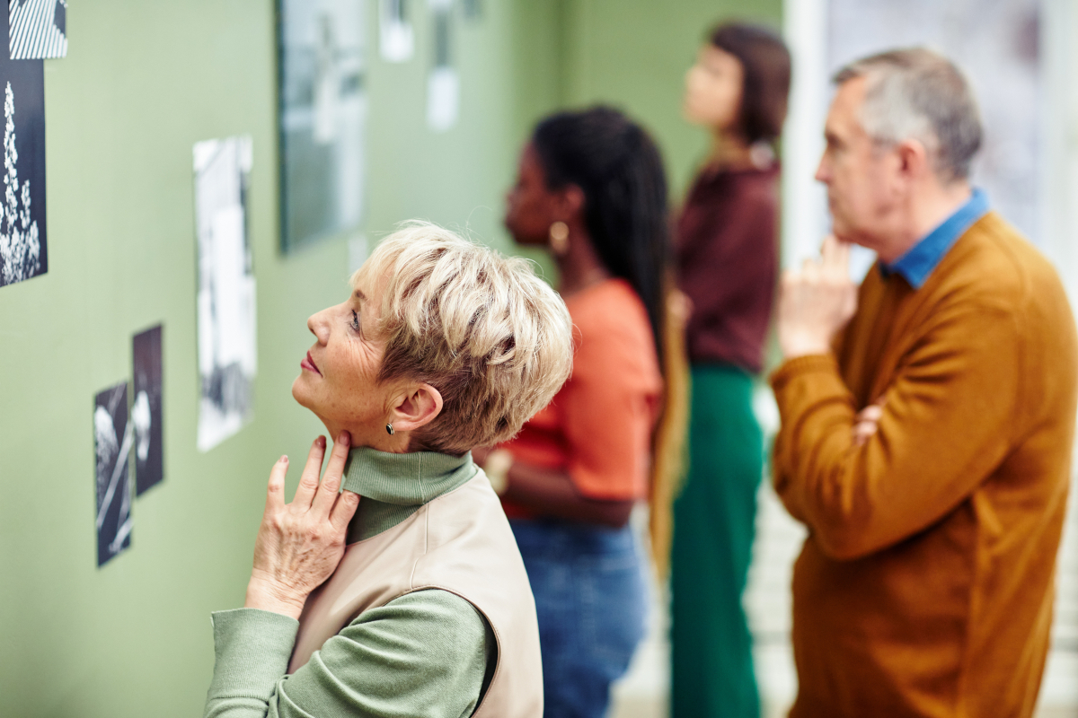 A group of people viewing art on display at a museum.