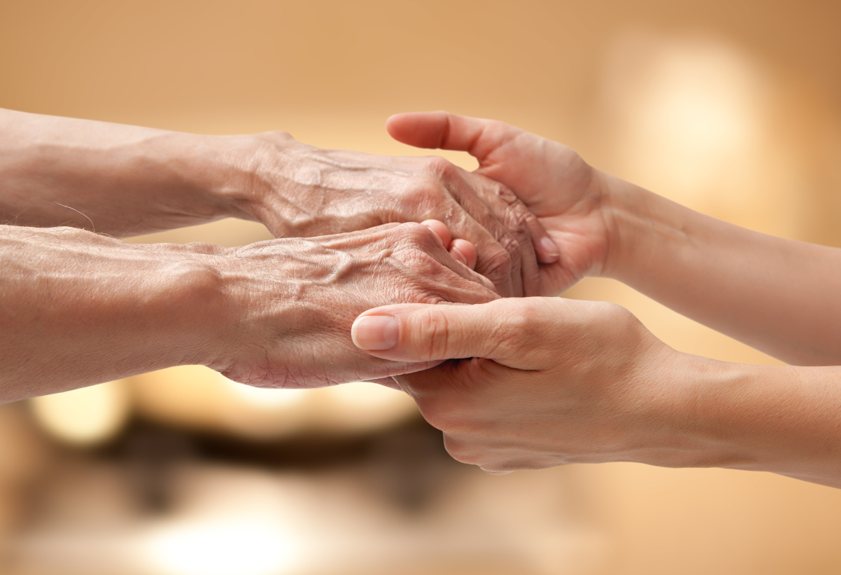 Female hands holding elderly male hands, care concept.