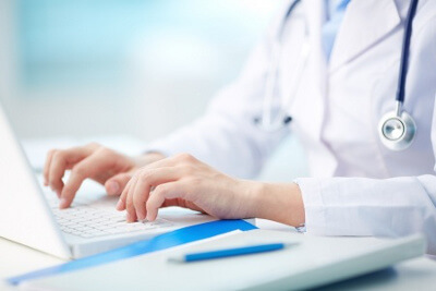 Doctor's Hands Typing on Laptop